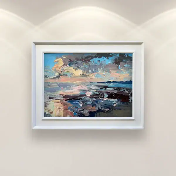 An original sunset seascape oil painting by Agostino Veroni, framed with a white modern wood frame, hanging on a light wall in an elegant living room above a white leather armchair.