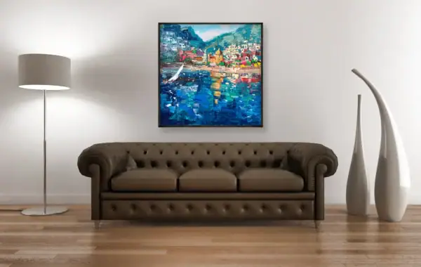 Agostino Veroni's vibrant Positano beach scene painting with a white sailboat, displayed above a classic brown leather Chesterfield sofa.