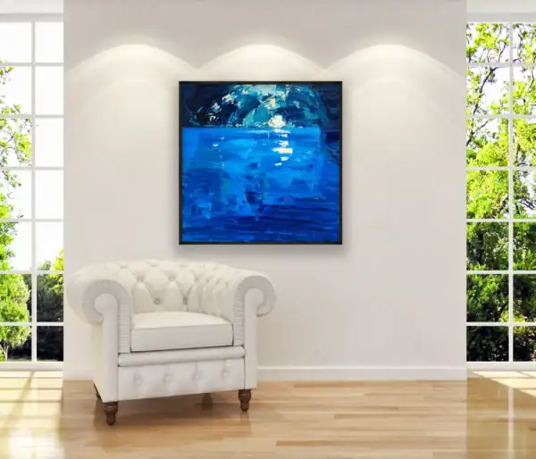 Original Blue Grotto oil painting by Agostino Veroni with a thin modern wood frame, shown in a bright office decor or living-room setting with a white armchair and a large window in the background.