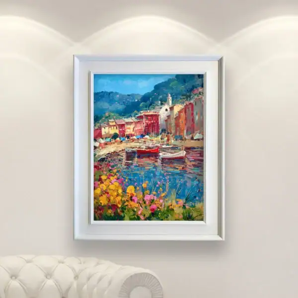 An original Portofino oil painting by Agostino Veroni, framed with a white modern wood frame, hanging in an elegant living room on a light wall above a white leather