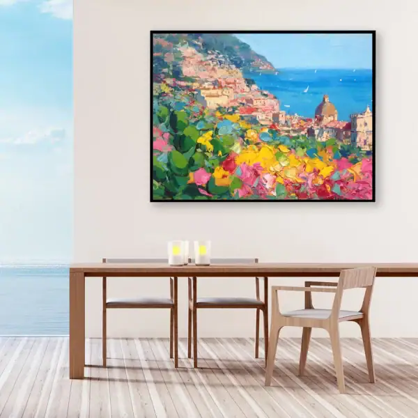 Original Positano oil painting by Agostino Veroni displayed in a bright modern dining room with a large wooden table and windows overlooking the ocean.