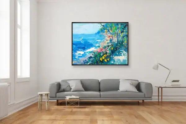 Panoramic oil painting of a Positano coastal path by Agostino Veroni, featured in a contemporary living room setting above a grey sofa.