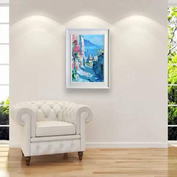 Original Positano coastal alley painting by Agostino Veroni, displayed in a bright modern living room next to a white leather armchair.