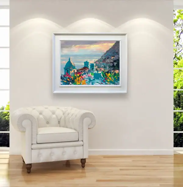 Original sunset oil painting of Positano by Agostino Veroni, featured in a bright modern living room next to a white leather armchair.