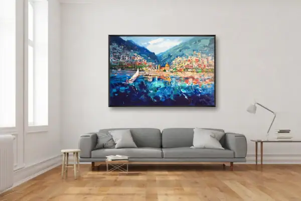 Hand-painted Positano seascape by Agostino Veroni showing a sailing boat, featured above a grey contemporary sofa in a bright, airy living room.