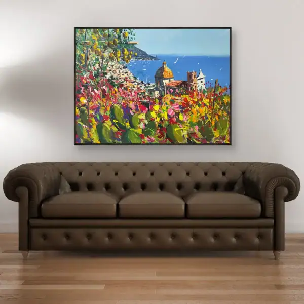 Agostino Veroni's original Positano oil painting with cactus and flowers, displayed above a classic brown leather Chesterfield sofa in a refined interior.