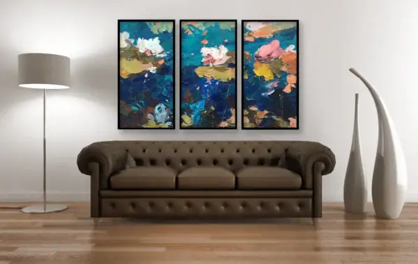 Three-panel water lilies oil painting by Agostino Veroni displayed in a classic living-room setting above a dark brown leather Chesterfield sofa, showing the contrast between the floral artwork and traditional furniture.