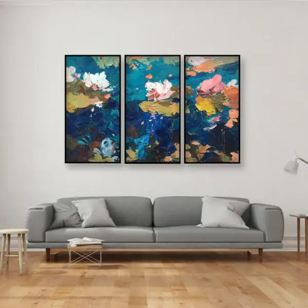 An original water lilies triptych oil painting by Agostino Veroni, featuring three vertical panels with black modern frames, hanging in a modern living-room above a long grey contemporary sofa.