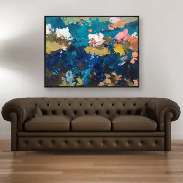 An original large oil painting by Agostino Veroni, featuring pink and white water lilies, displayed in a modern living room on a white wall above a brown leather sofa.