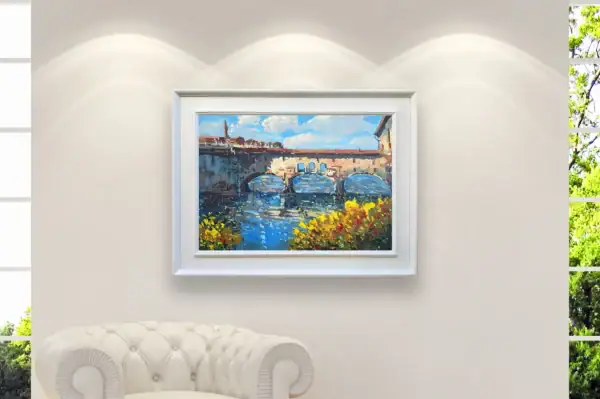 Original oil painting of Ponte Vecchio in a white frame, displayed on a minimalist gallery wall under professional spotlights.