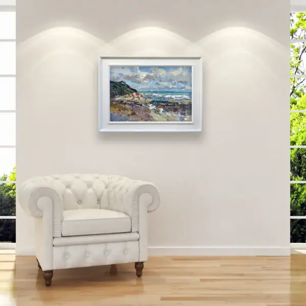 Framed original oil painting of a rocky Italian coast perfectly complementing a sophisticated interior with a classic white armchair.