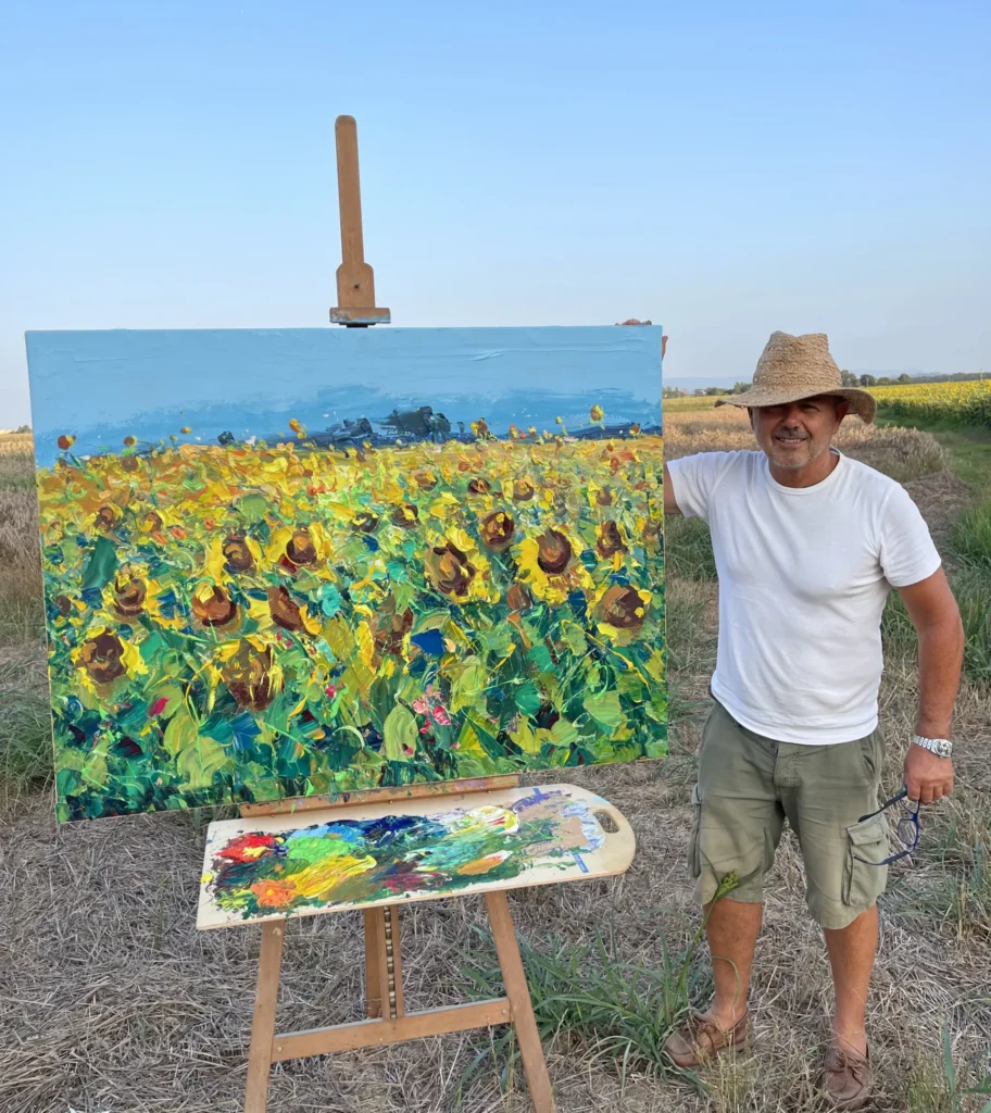 Agostino Veroni painting en plein air a sunflower field in Tuscany, working outdoors on an original oil painting on canvas inspired by natural light and countryside landscape