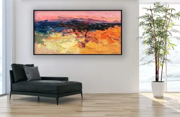 The "Pink Sky" abstract landscape oil painting displayed in a minimalist interior next to a black chaise longue and a tall indoor plant, highlighting its sophisticated aesthetic.