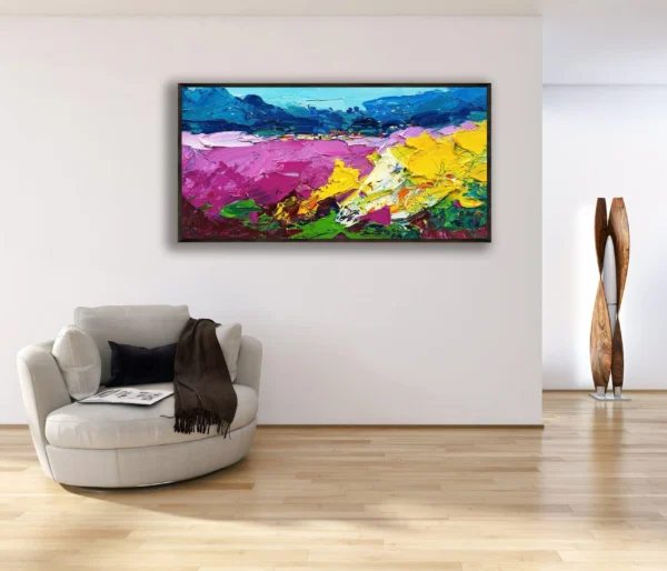 The horizontal sunflowers and lavender painting hanging in a bright contemporary room above a comfortable white armchair.