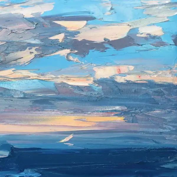A detailed close-up focusing on the central horizon where bright yellow and orange light breaks through blue clouds and reflects on the textured sea surface.