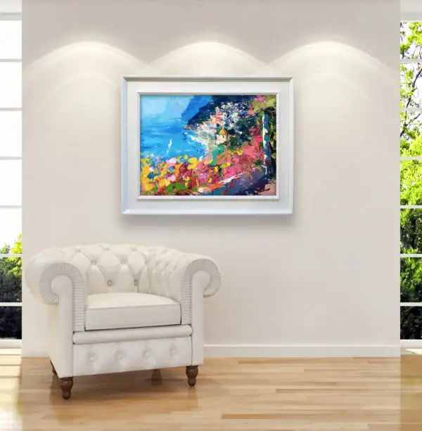 Large framed coastal painting styled beautifully in a bright luxury lounge room or modern office space next to an accent armchair.