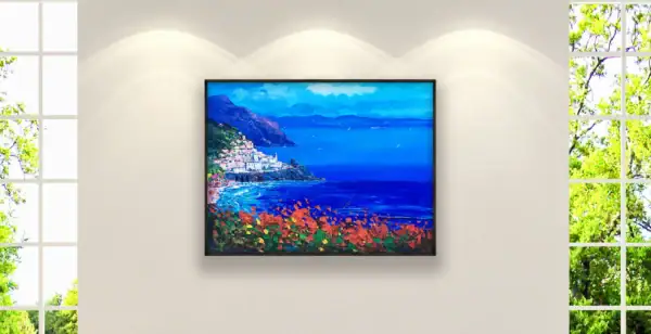 The horizontal Amalfi seascape canvas styled inside an elegant dark frame as a vibrant focal point on a white wall in a luxury contemporary lounge room.