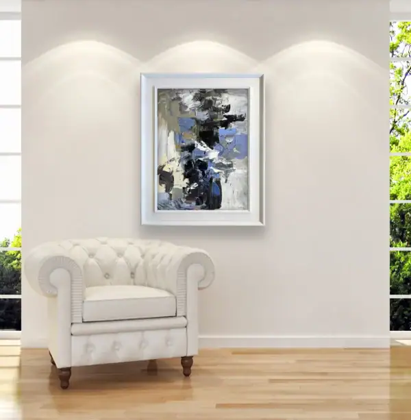 The framed vertical contemporary artwork displayed elegantly on a clean white gallery wall above a classic white leather tufted armchair.