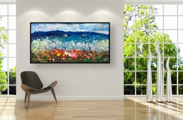 The horizontal spring orchard painting displayed in a bright contemporary space next to a sleek black chair and tall white floor vases.