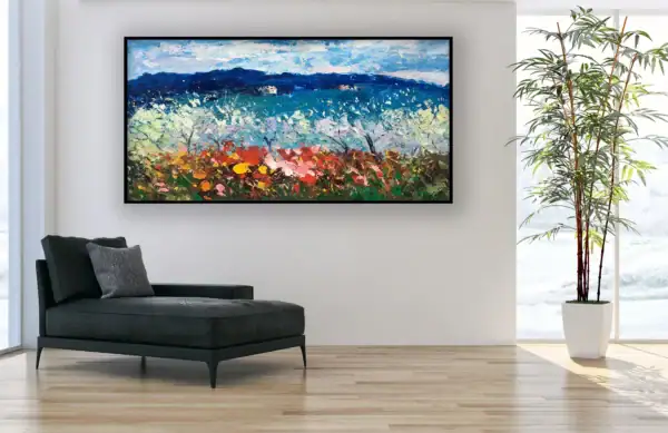 The horizontal textured blossoms landscape artwork styled in a bright modern room next to a black leather chaise longue.