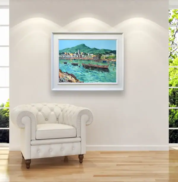 The horizontal Ischia Porto landscape painting styled inside an elegant white frame as a bright focal point on a luxury lounge room wall next to a white leather armchair.