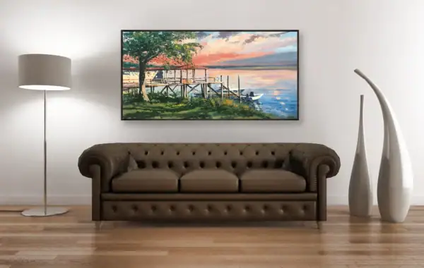A frontal view of the colorful sunset landscape artwork displayed above a dark brown leather Chesterfield sofa in a refined interior.