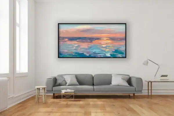 The large horizontal pastel sunset painting displayed on a minimalist white wall above a long grey sofa in a bright contemporary apartment.