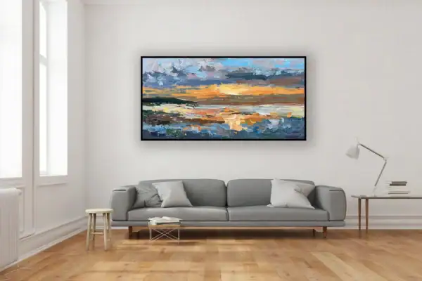 The colorful sunset seascape painting beautifully styled above a grey sofa with minimalist wooden details.