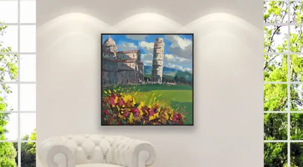 The colorful Tuscany scene canvas hanging on a clean white gallery wall with spotlighting above a sophisticated white leather tufted armchair.