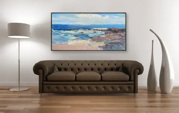 A frontal view of the colorful Mediterranean shoreline artwork styled above a dark brown leather Chesterfield sofa.