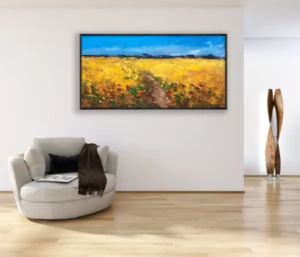 A large horizontal impressionist Tuscan wheat field landscape painting hanging on a white wall in a modern living room next to a light circular armchair.