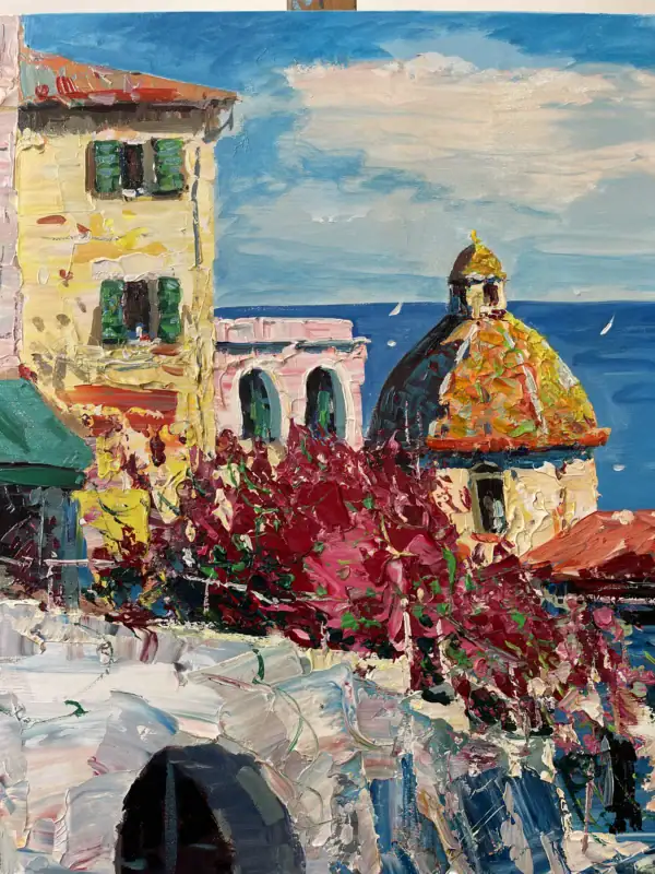 Detailed shot showcasing the heavy impasto texture of premium oil paint shaping the coastal village architecture and the vibrant pink blooming flowers.