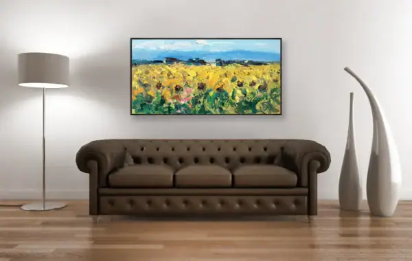 The vibrant impressionist sunflower field painting in a luxury interior, perfectly positioned above a classic brown leather Chesterfield sofa.