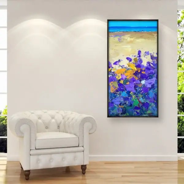 Modern impressionist vertical original purple floral beach oil painting styled as home decor on a white wall above a Chesterfield armchair.