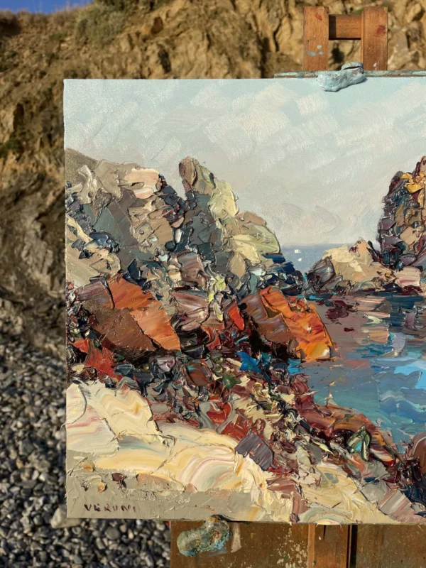 A modern impressionist sea cliffs oil painting on a wooden easel showing heavy impasto and palette knife textures in natural light.